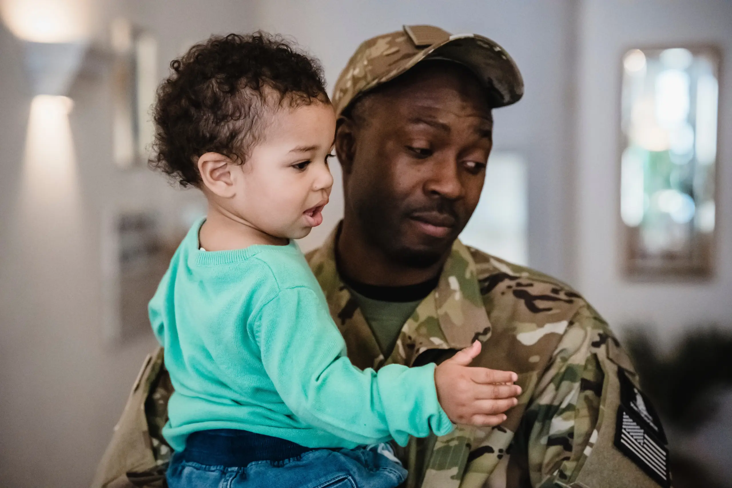 Service member father holding toddler.