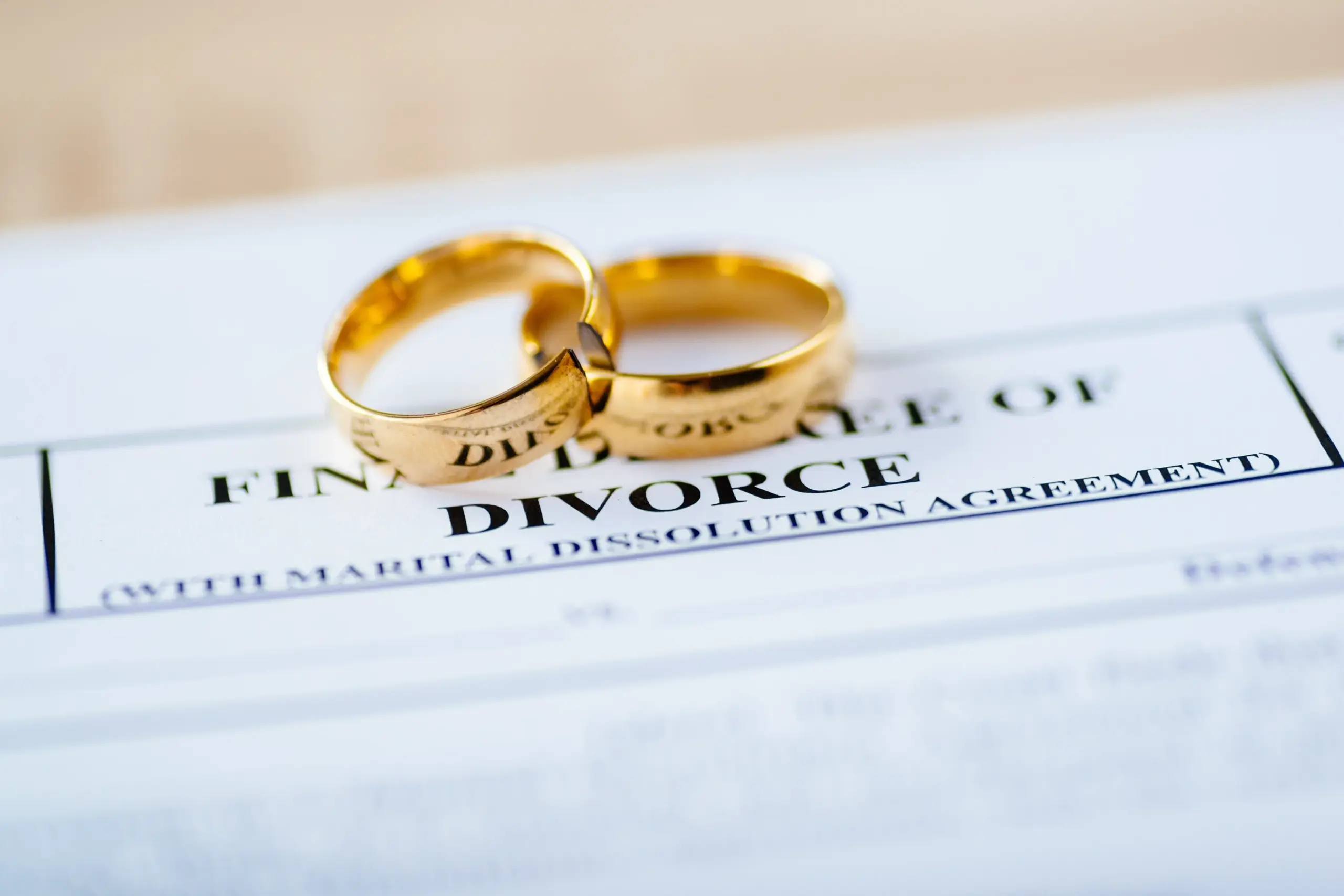 Two gold wedding rings on divorce decree paperwork.