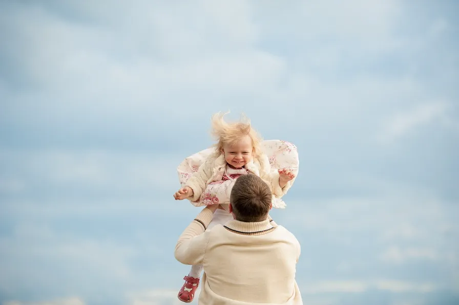 Father throwing his daughter in the air.