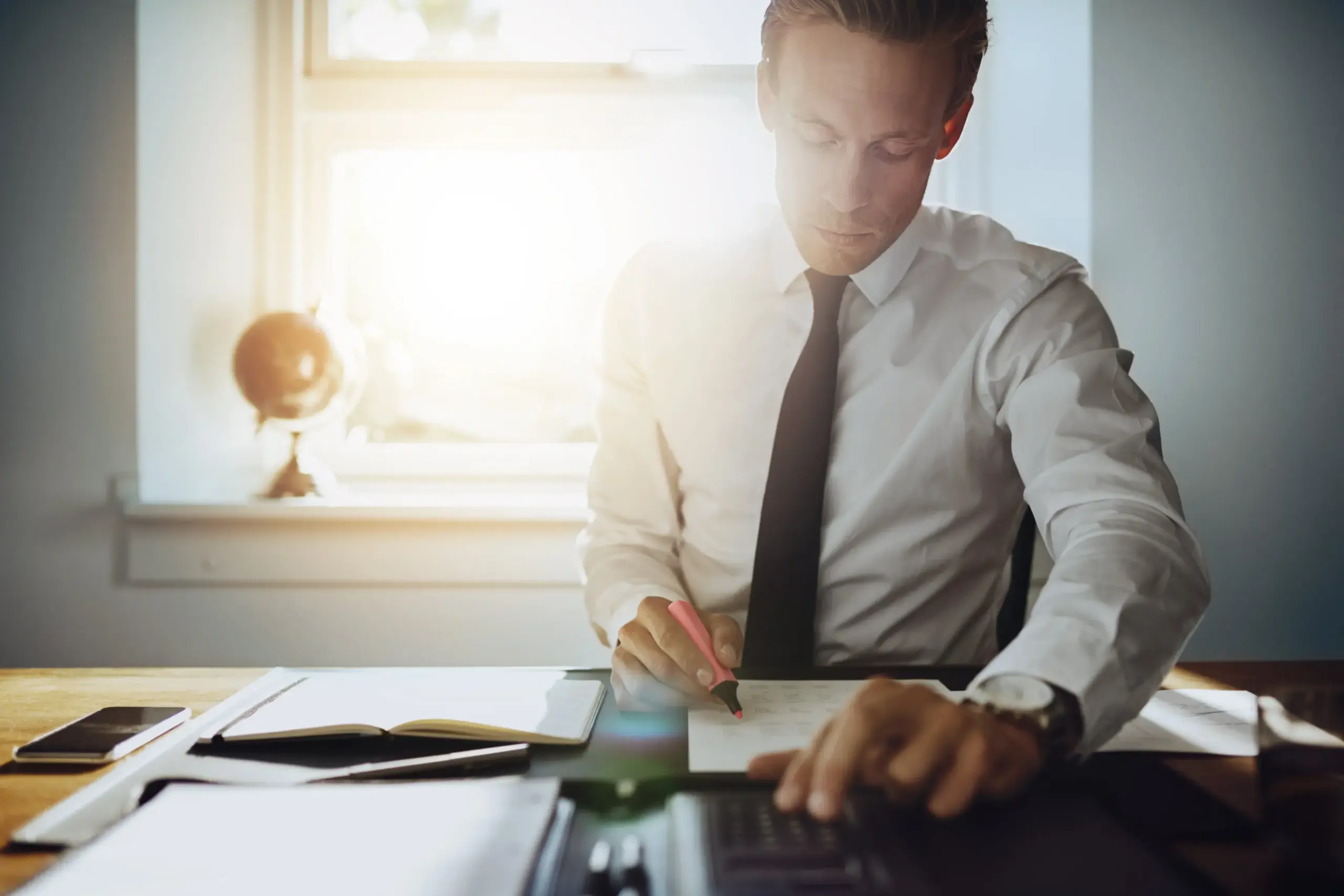 An attorney drafting Prenuptial and Postnuptial Agreements at his desk.