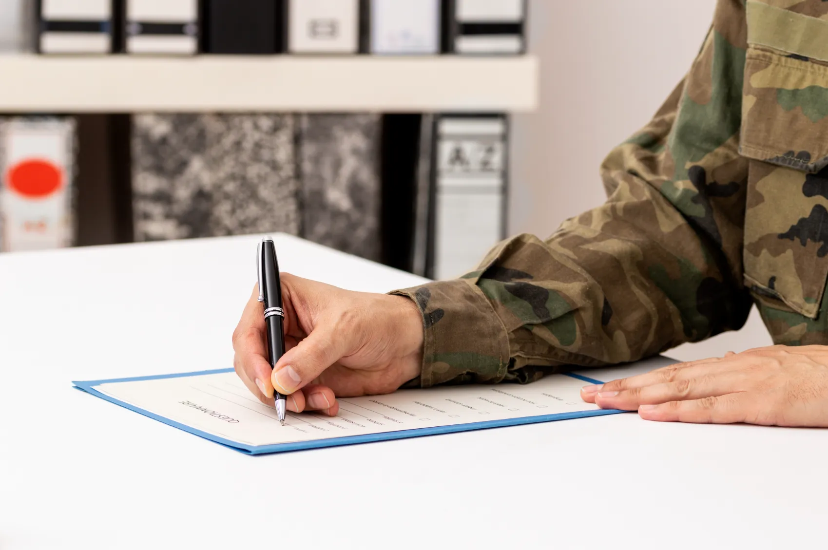 A military service man signing paperwork.
