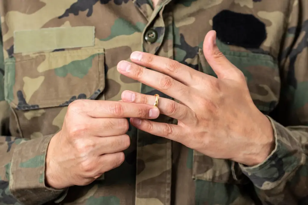 A military service man removing his wedding ring.