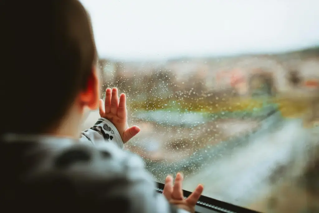 A toddler looking out a bus window.