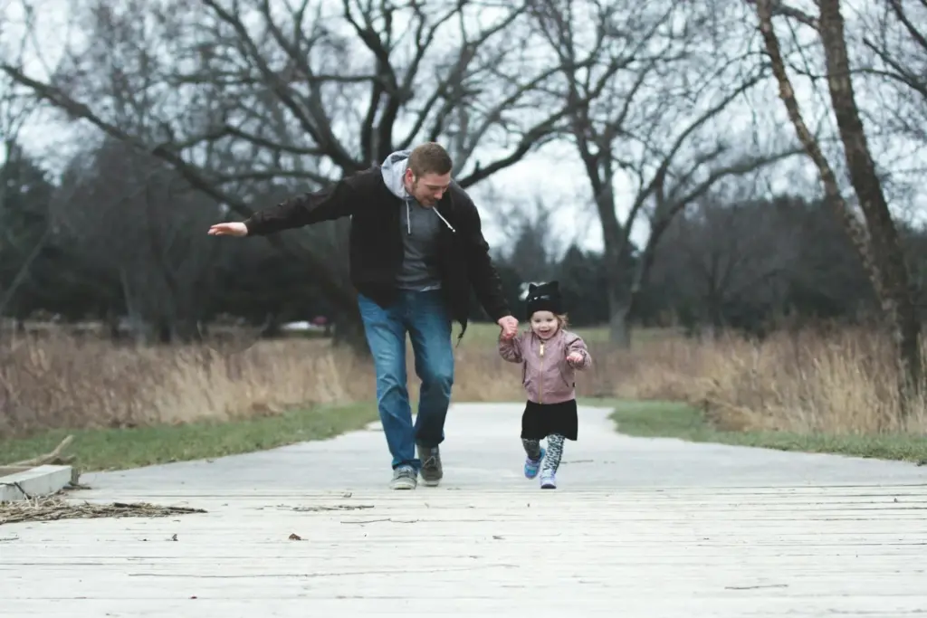 Father and child running along road.